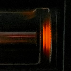 Das Foto zeigt die drei linienartigen Bereiche, in denen das Neongas durch Teilchenstöße zum Leuchten angeregt wird.