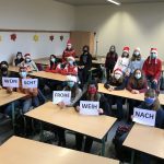 Die Klasse 8c hält mit Weihnachtsmützen bekleidet die Worte „Das Elo wünscht frohe Weihnachten!“ hoch.